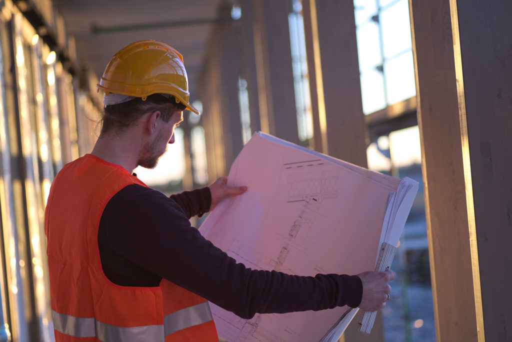Freundlich lchelnder Mann mit Helm auf einer Baustelle